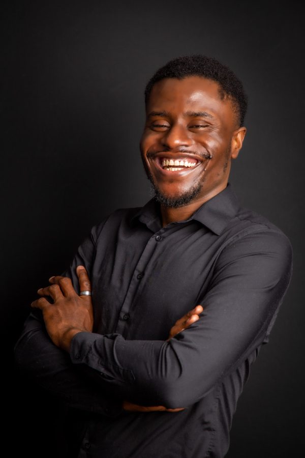 Kelechi smiling studio portrait with arms crossed