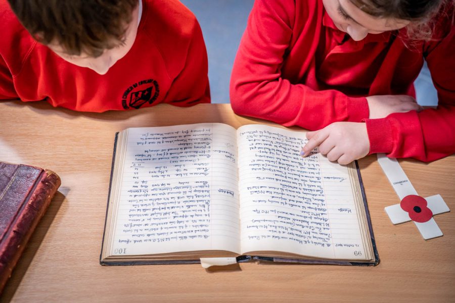 School children reading historical document