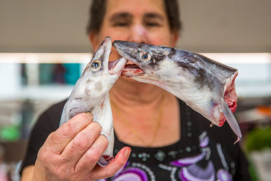 Spanish fish market trader with kissing fish